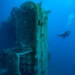 Diver exploring a sunken shipwreck underwater. - CertiDive