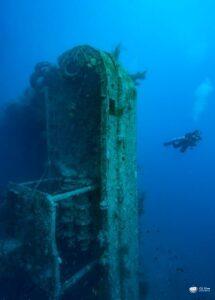 Diver exploring a sunken shipwreck underwater. - CertiDive